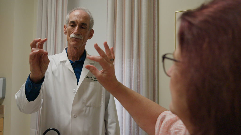 Dr. Stephen Salloway evaluates an Alzheimer's patient by having them touch their pointer finger and thumb.