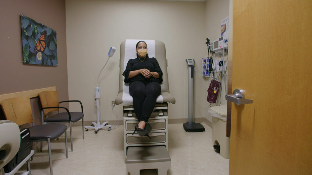 Migraine patient waiting on exam table.