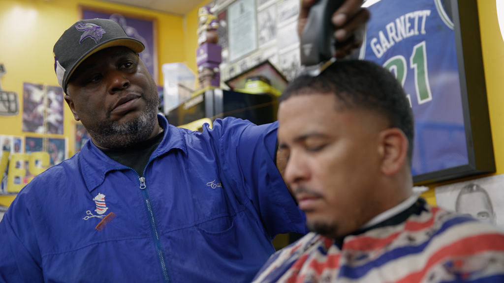 Man shaves head in a barbershop.