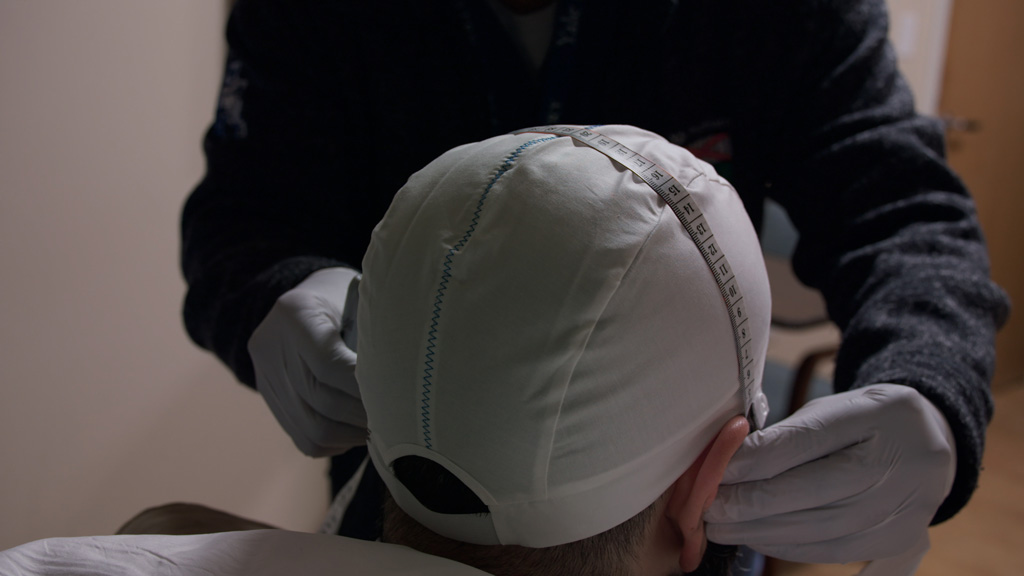 Patient's head is measured for placement of transcranial magnetic stimulation procedure